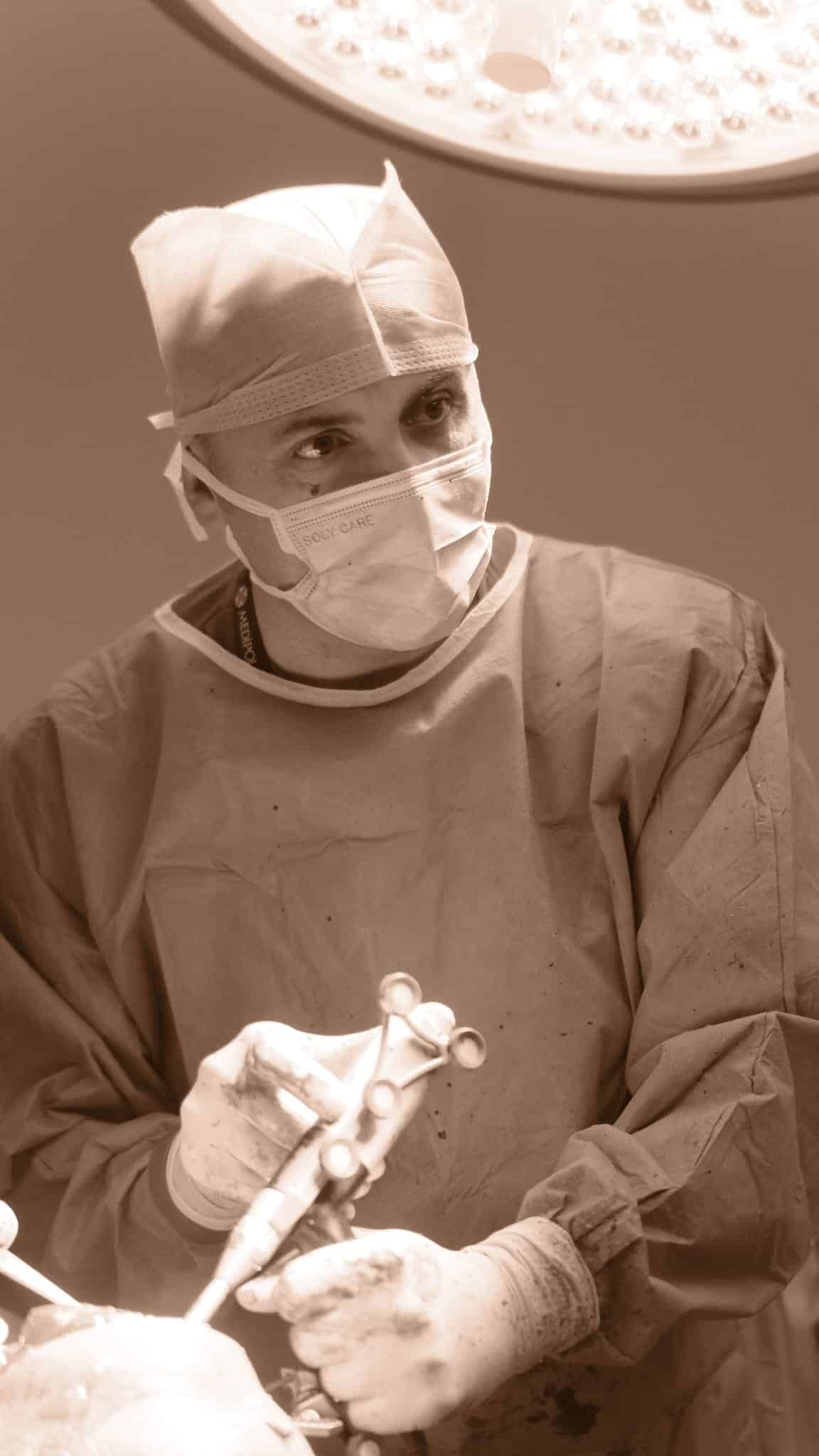 Prof. Dr. Serdar Yüksel ameliyathanede cerrahi aletle çalışırken